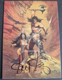 Illustration of a warrior and a woman with a sword, signed by Moebius, on a desert-themed card.