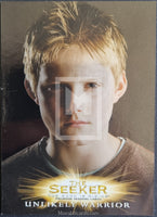 Trading card featuring a young boy with blonde hair and a brown shirt, labeled 'The Seeker: Unlikely Warrior'.