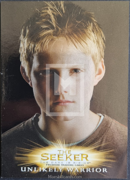 Trading card featuring a young boy with blonde hair and a brown shirt, labeled 'The Seeker: Unlikely Warrior'.