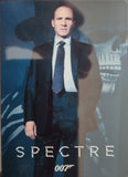 Character from 'Spectre' with a suit and tie, standing in front of a dark background with a skull.