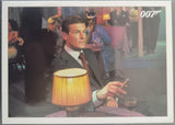 Man sitting at a table with a lamp and glass, wearing a suit and smoking a cigarette, with '007' branding.