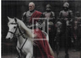 Man on a white horse with armored followers in a dark setting