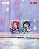 Two illustrated Kayou character cards displayed upright on a reflective surface in a softly blurred pastel studio setting. The left card features a pink-haired character and the right card features a dark-haired character, both with colorful anime-style artwork and the word 'HUNTER' visible.