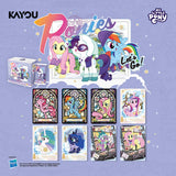 My Little Pony collectible card set packaging and card display on a light lavender background. The image shows the product box, a large illustrated front card with the title 'My Little Pony' and characters, and eight sample cards arranged below.